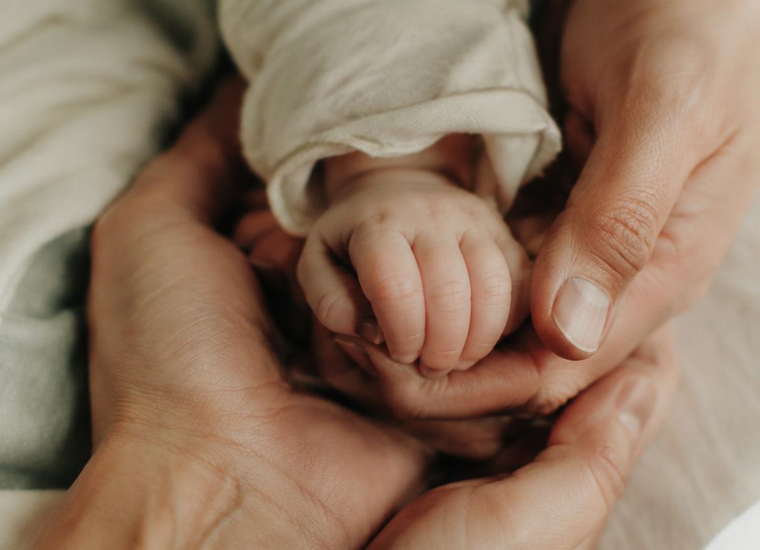 Mano di neonato nelle mani dei genitori
