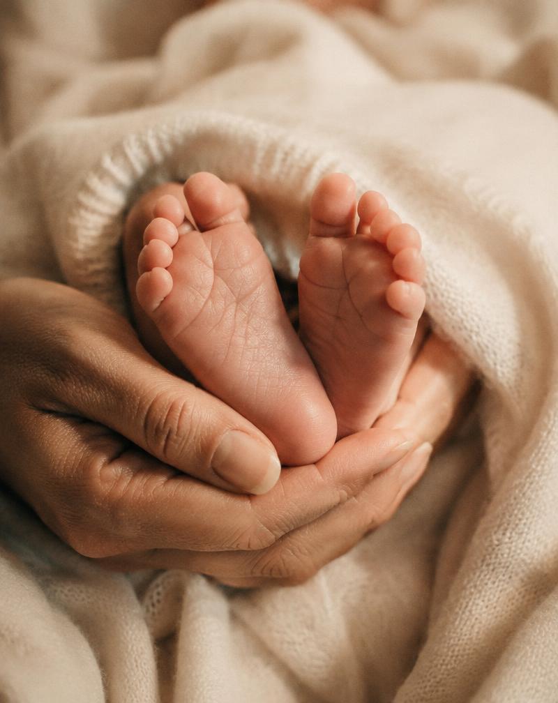 Piedini di neonato tra le mani della mamma